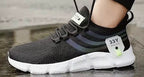 Black and white AeroKnit Runner sneaker worn on a wet reflective surface